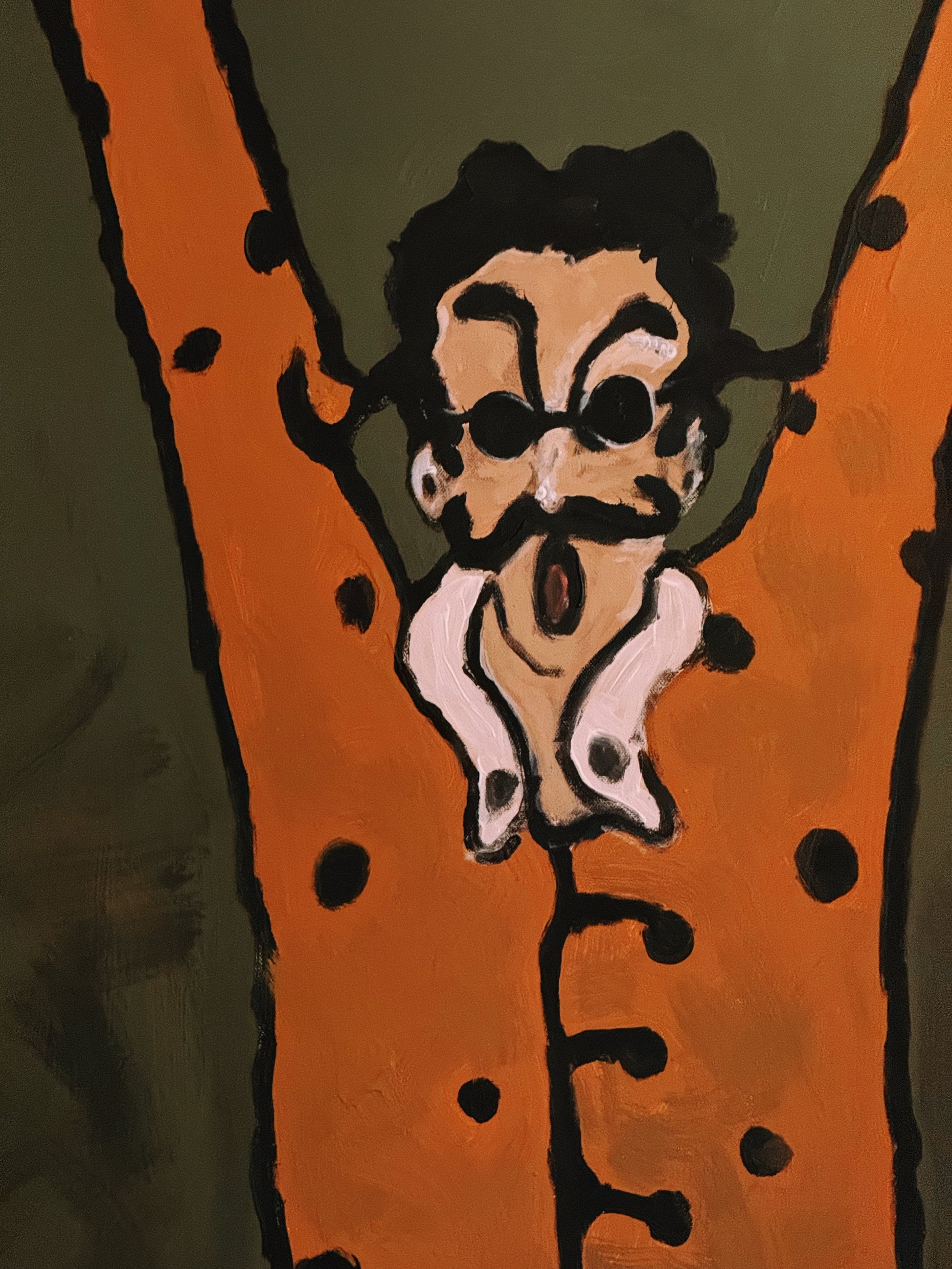 Cartoonish character with a mustache hanging from a branch on an orange background