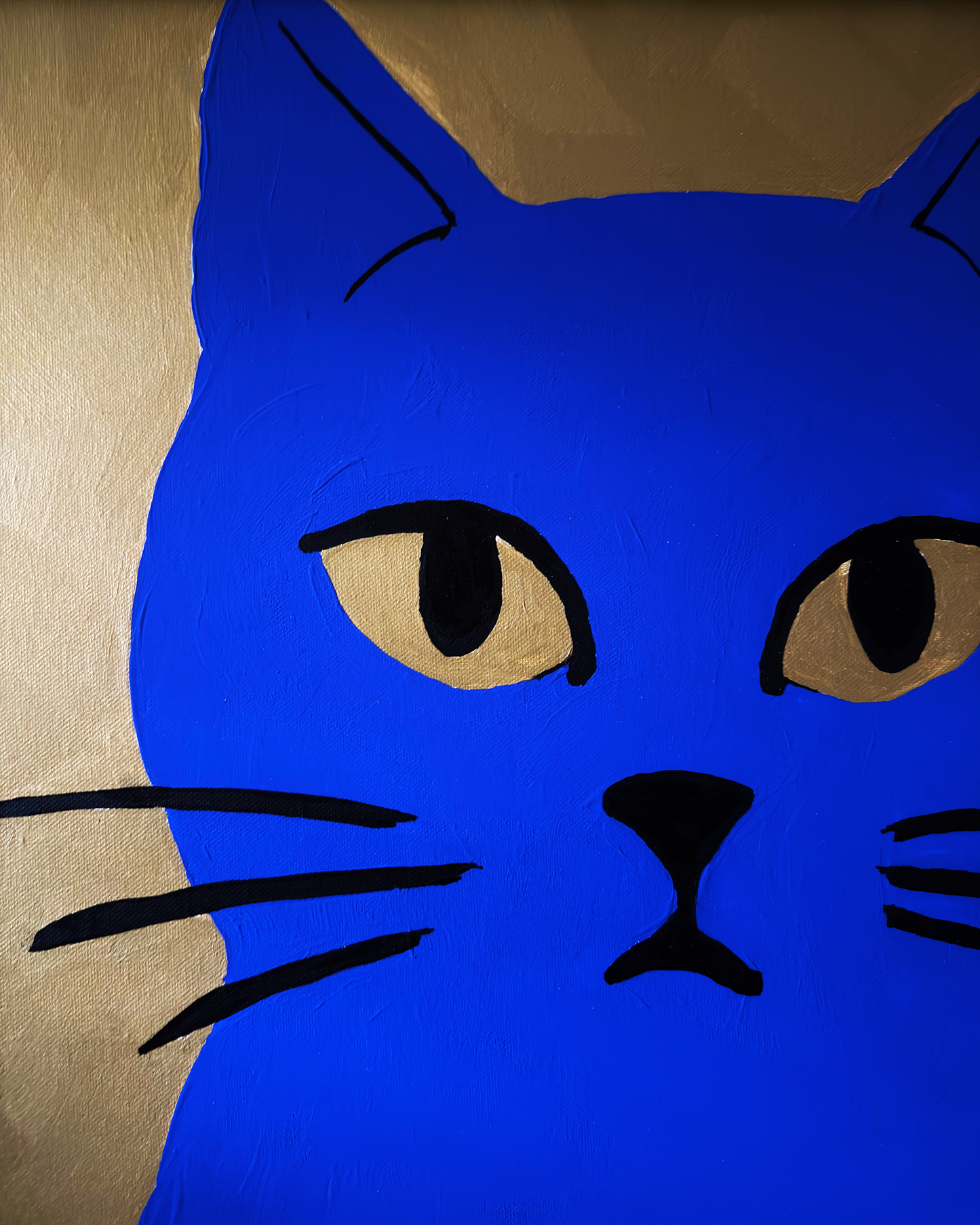 Blue cat face design on a gold background