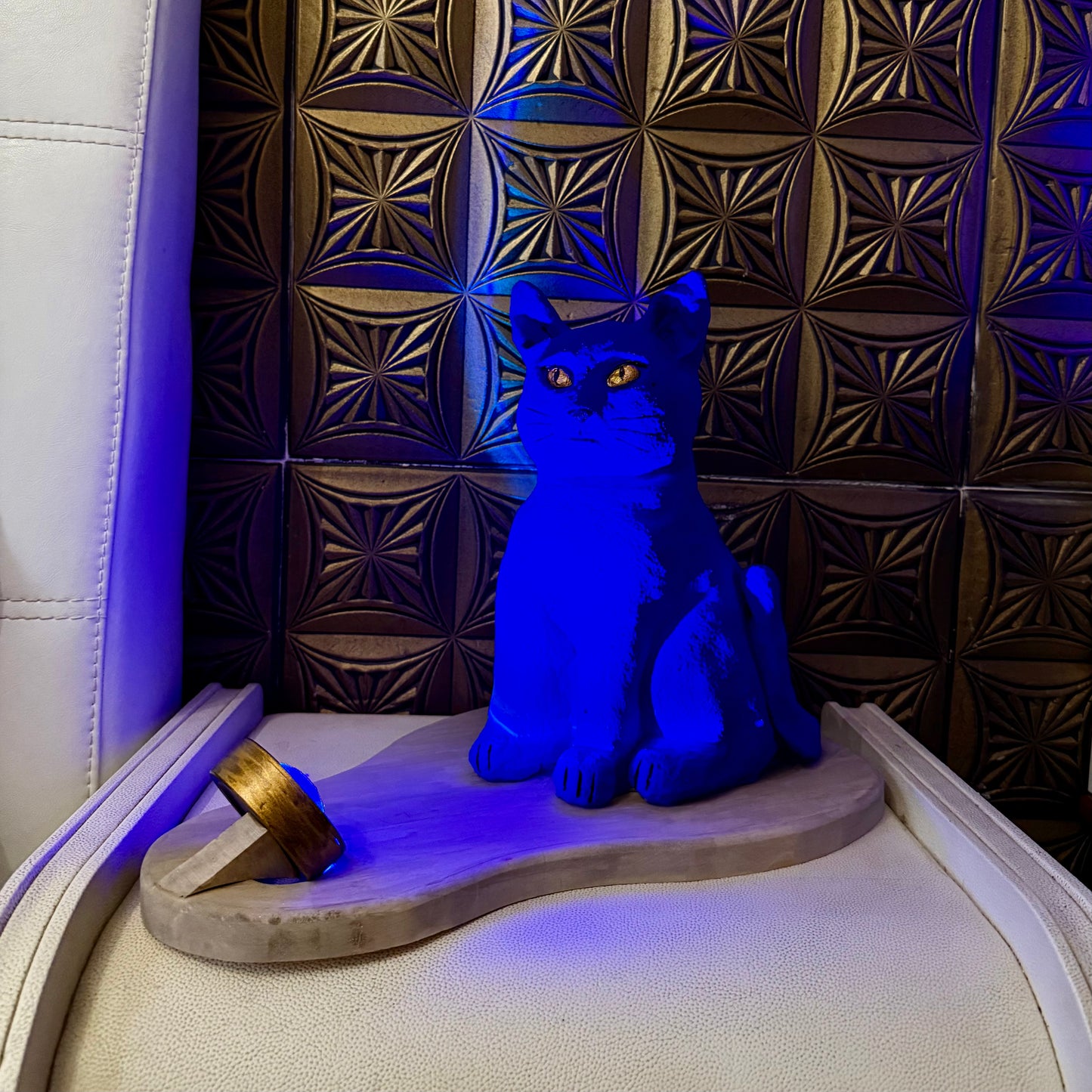 Blue cat-shaped object on a textured surface with geometric pattern