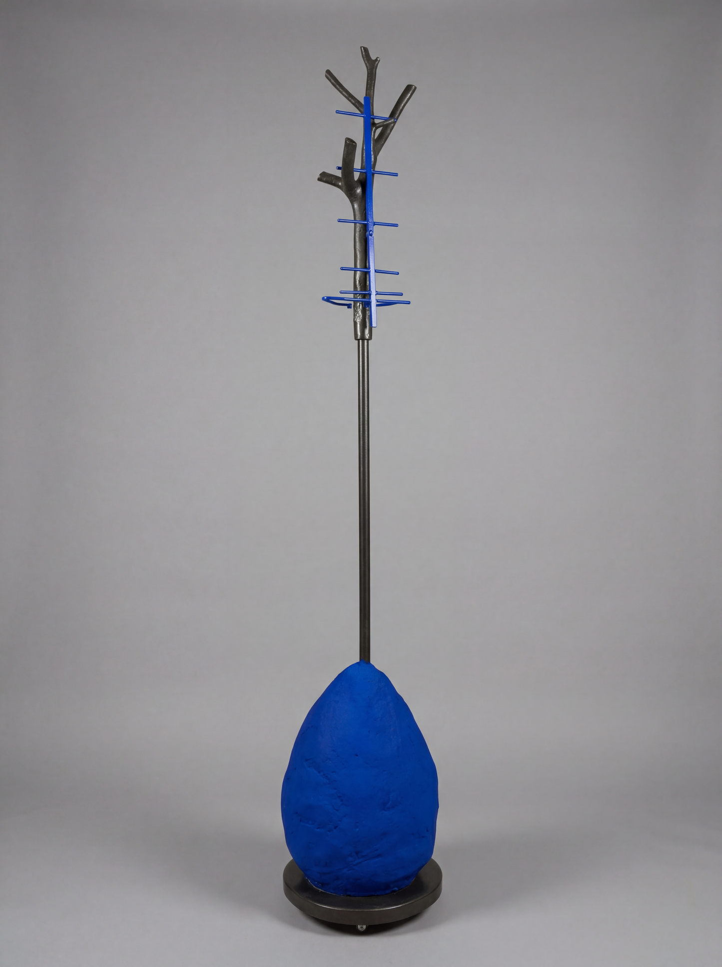 Blue coat stand with tree-like design on a gray background
