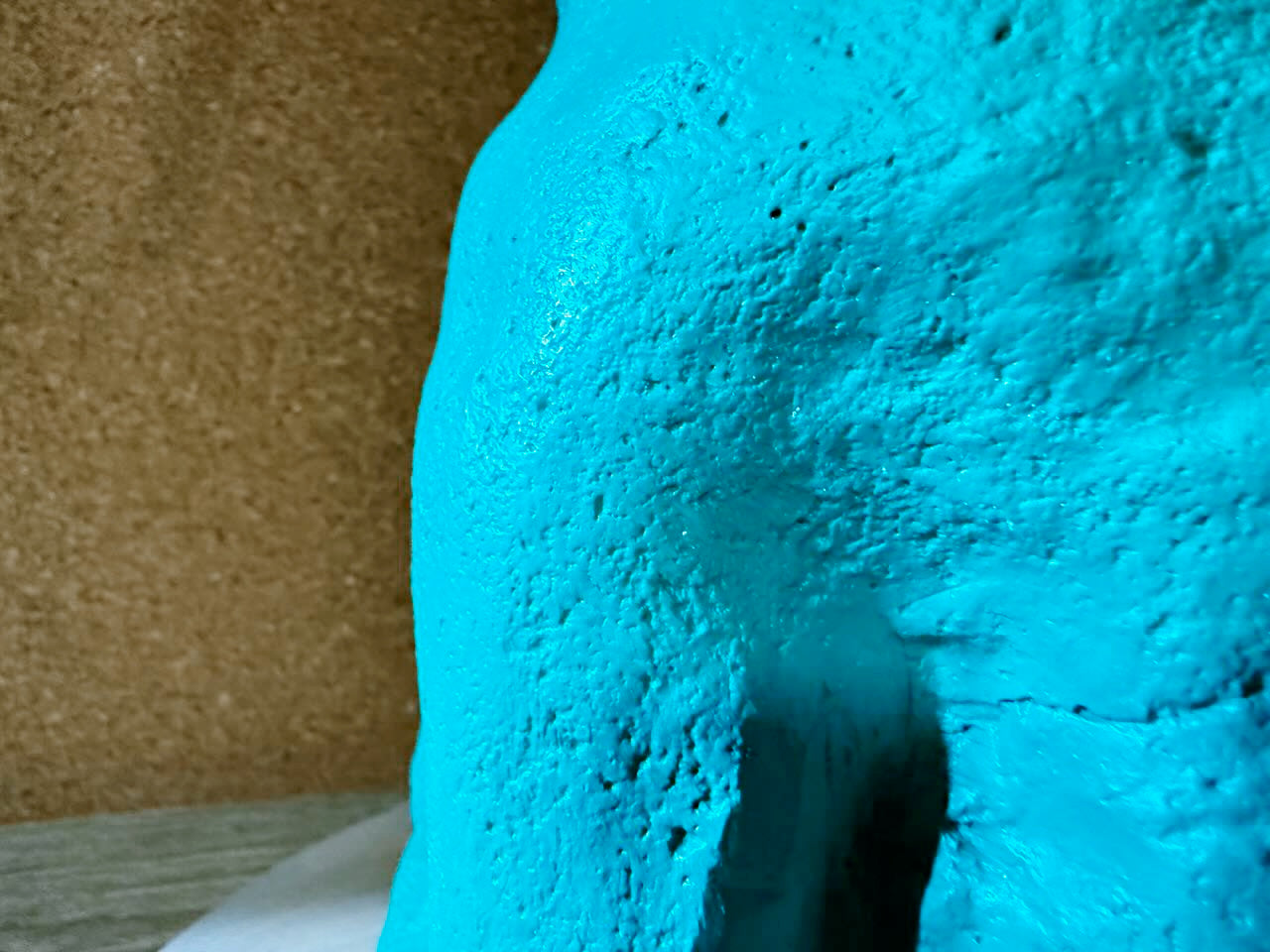 Close-up of a textured blue surface with a brown background