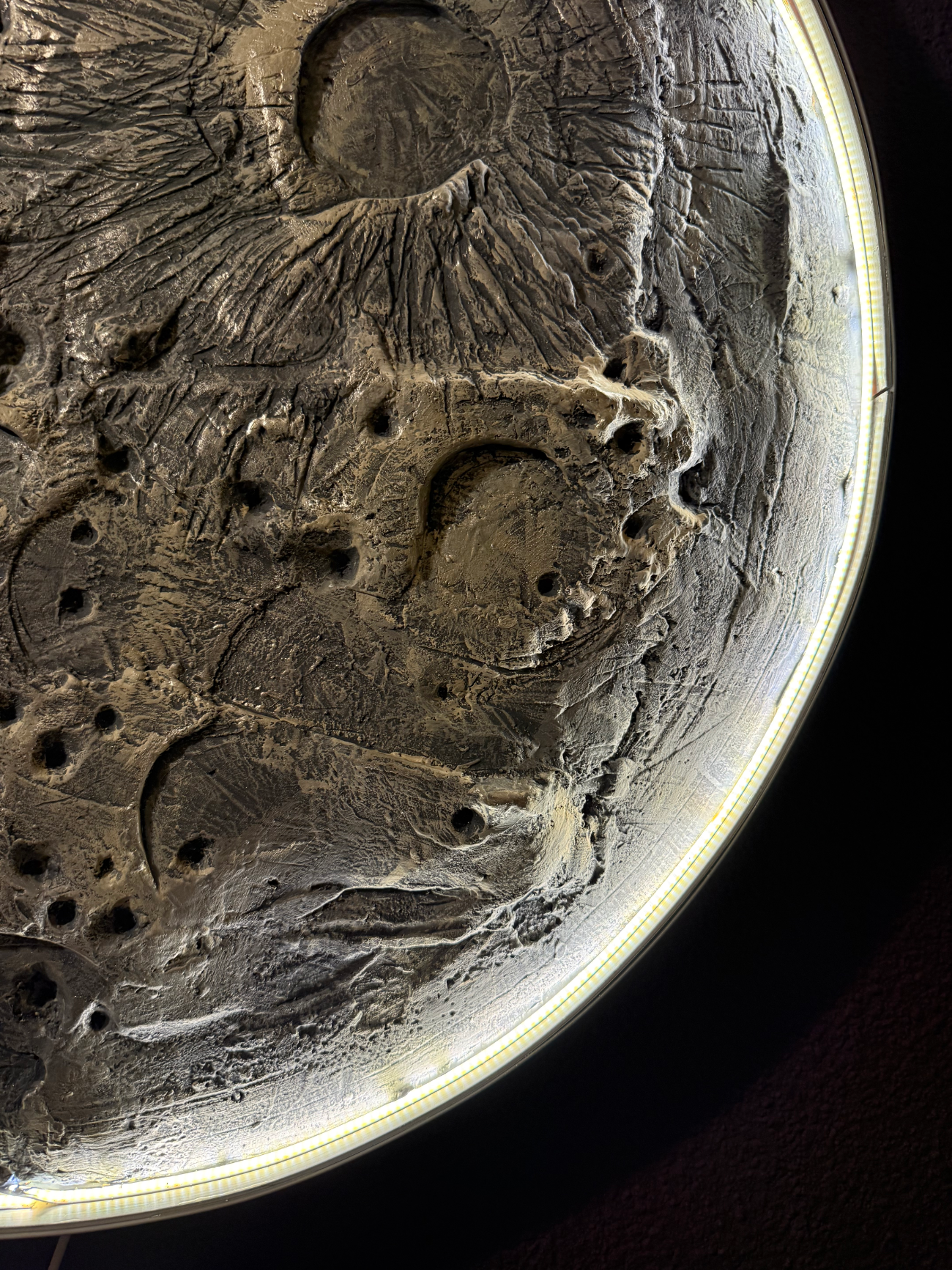 Close-up of a textured surface with embossed designs on a dark background