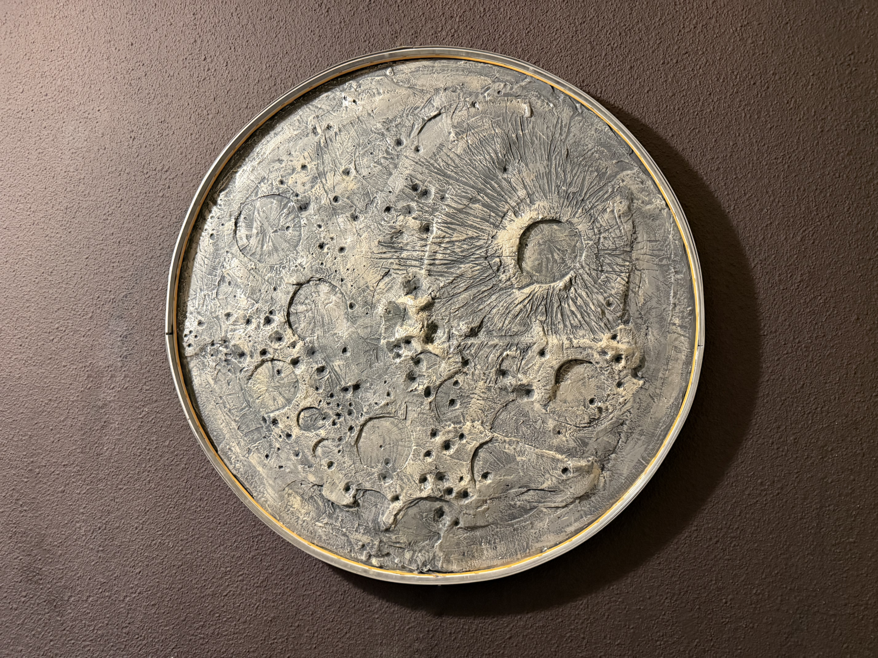 Decorative circular wall art with celestial design on a brown background