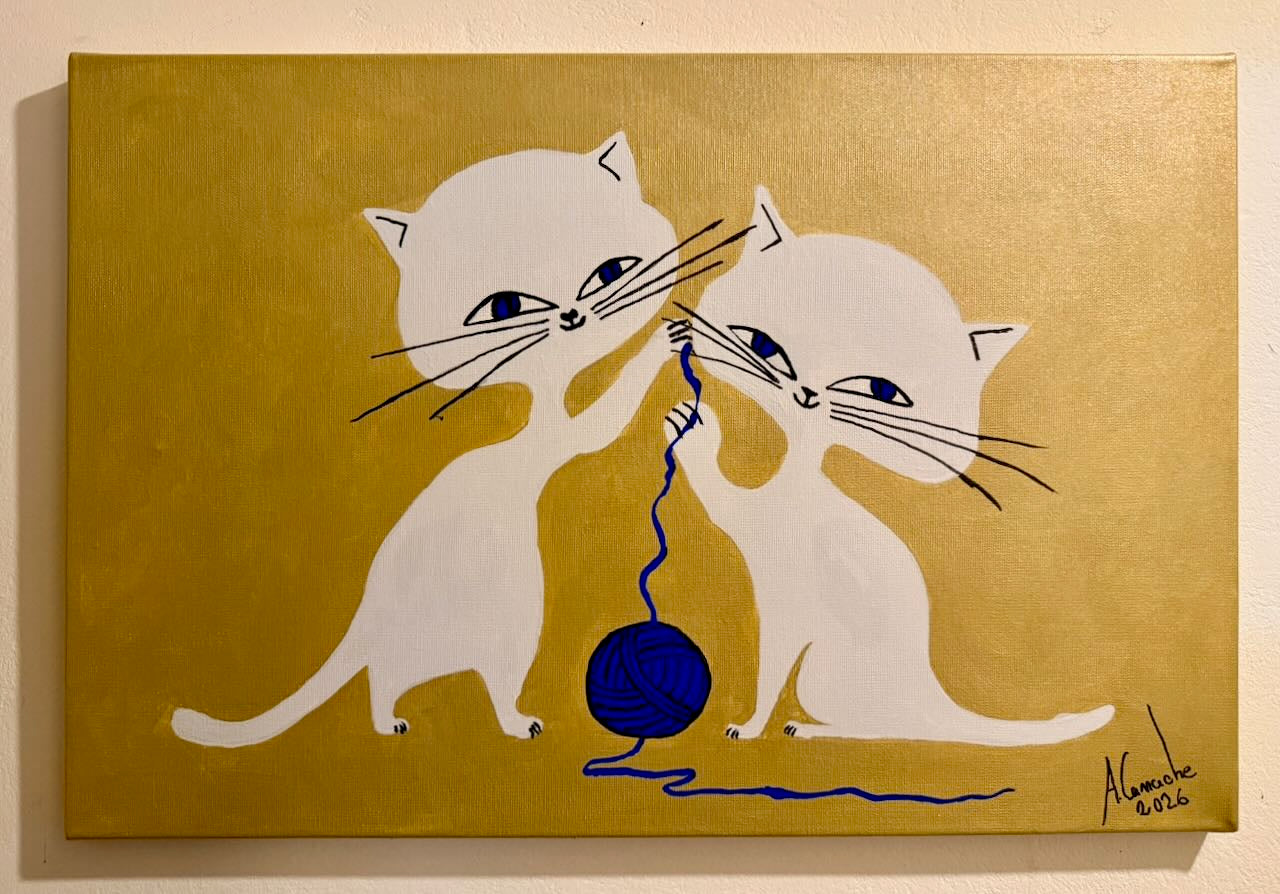 Two white cats playing with a blue ball on a gold background