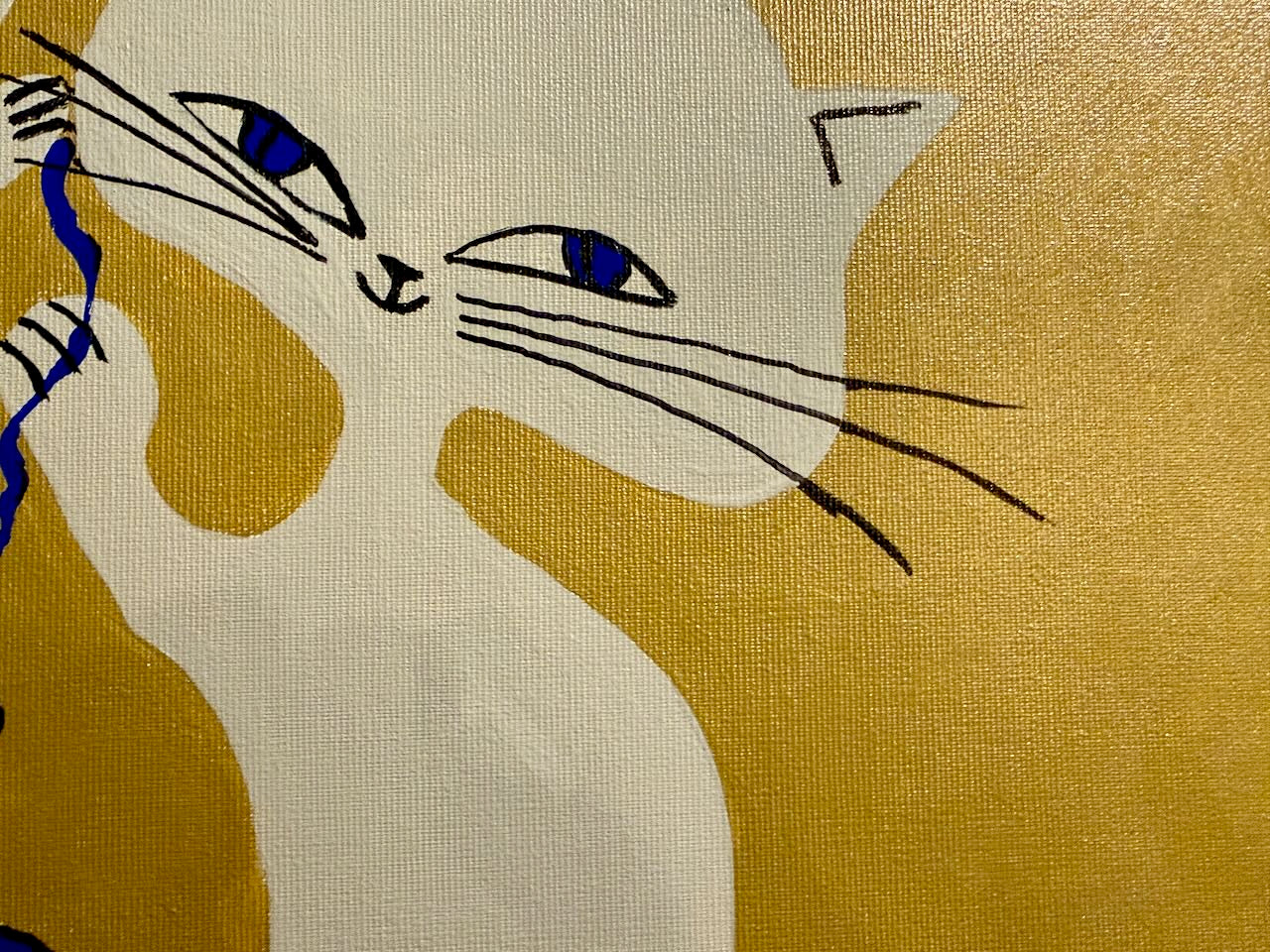 Embroidered design of a cat on fabric with gold background