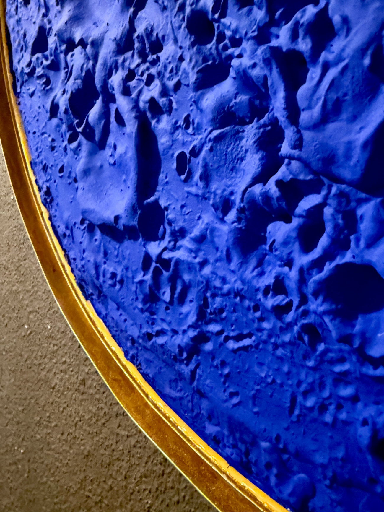 Close-up of a textured blue surface with a gold rim