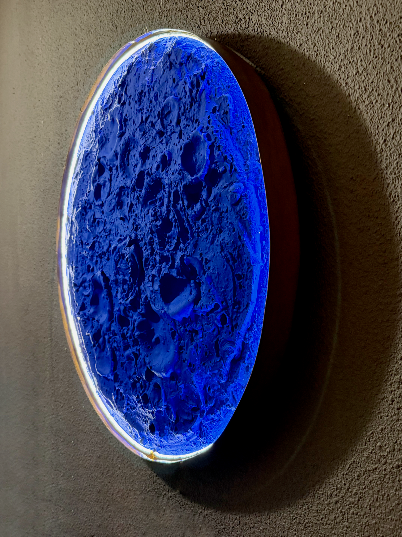 Blue textured oval object on a dark background